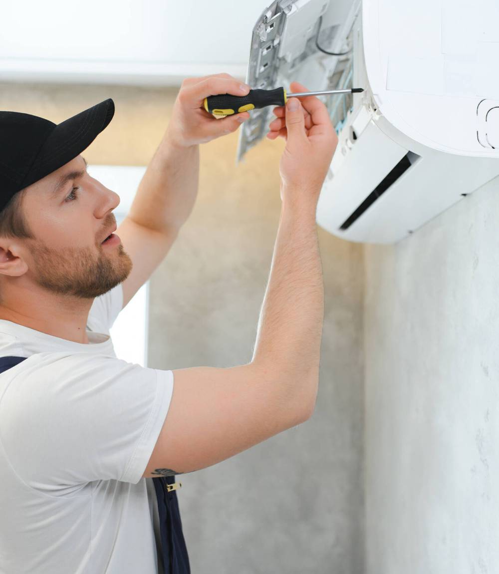 Happy Male Technician Repairing Air Conditioner. Happy Male Technician Repairing Air Conditioner